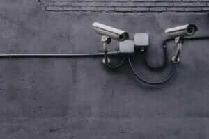 two surveillance cameras resized on a wall