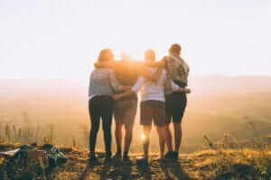 friends hugging each other while watching the sunrise
